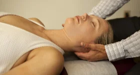 Chiropractor gently adjusting a patient's neck